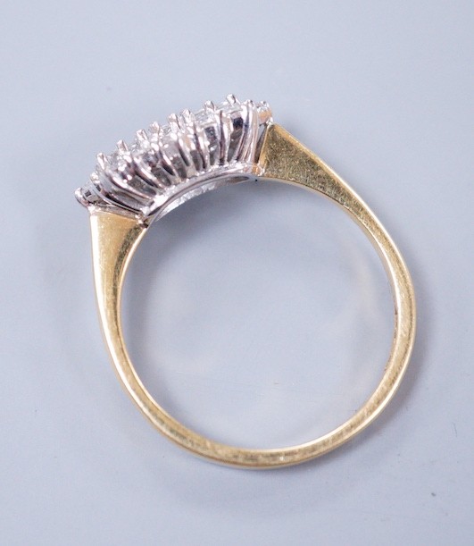 A modern 18ct gold, baguette and round cut diamond set shaped cluster ring, size O/P, gross weight 4.1 grams